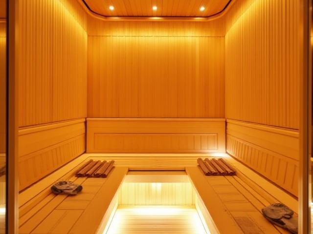 Intérieur de sauna luxueux avec des boiseries claires et un éclairage tamisé